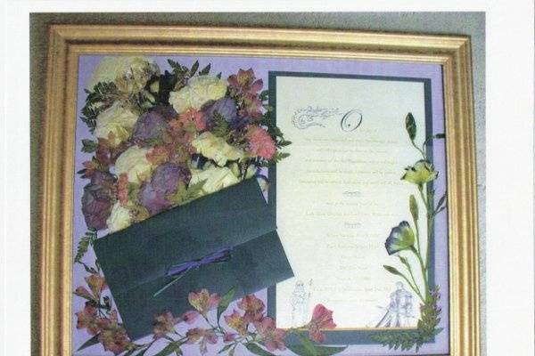 a scroll invite unfurled, displayed with the envelope and the bouquet flowers on a perriwinkle blue satin background
