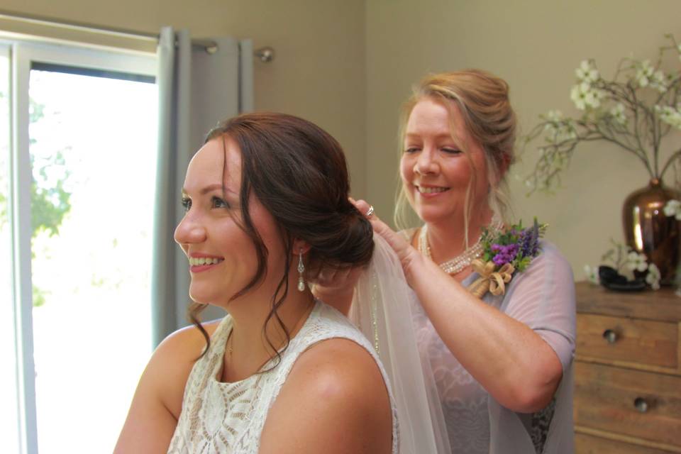 Bride's mom putting on veil