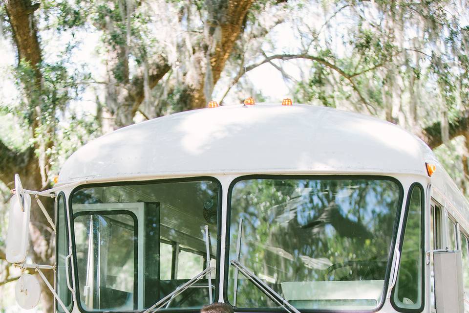 Newlyweds kissing in front of the cream vintage VW Bus