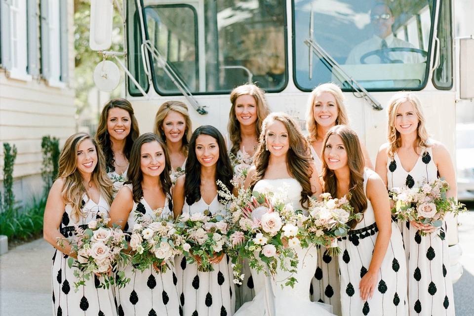 Bridesmaids with their bride in front of the bus