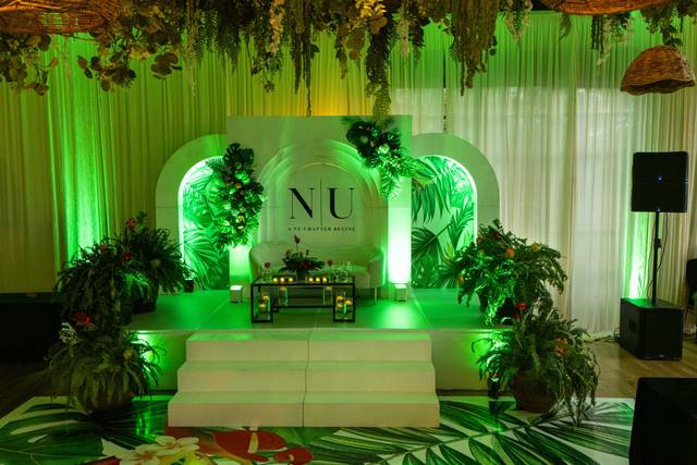 Green uplighting on a floral monogram stage