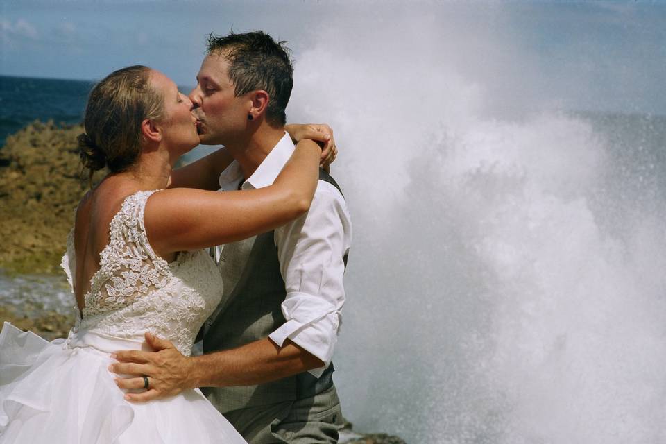 Couple kissing waves crashing