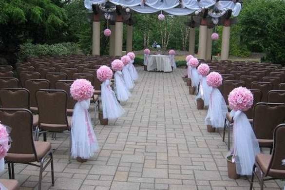 Pew markers of white tulle and balls of pink carnations