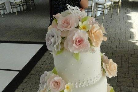 gum paste roses and frangipani flowers with piped butterflies and looped border