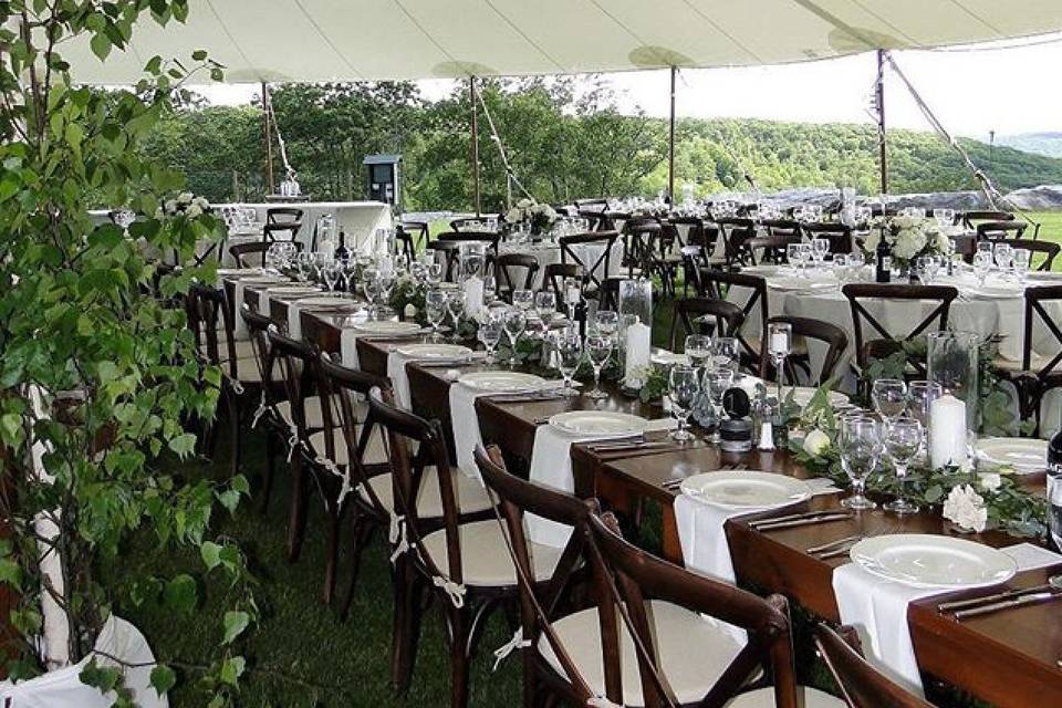 Inside Stillwater sail cloth tent with our farmtables and cross back chairs