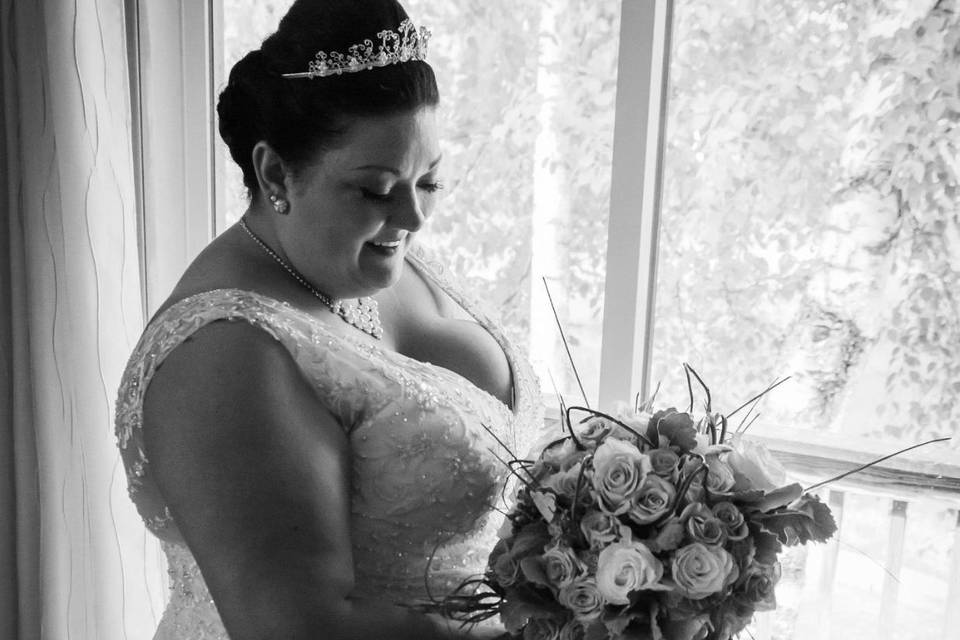 Bride by the window with her bouquet