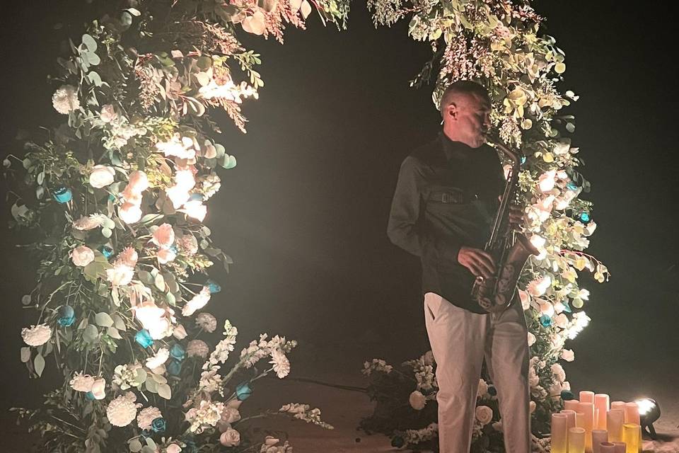 Sax player in front of flowers