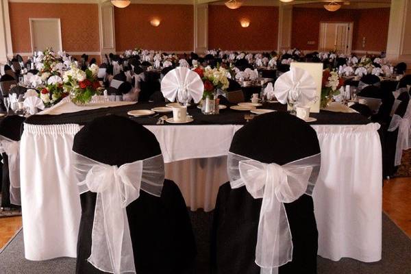 Black chair covers with White organza bows. Head table
