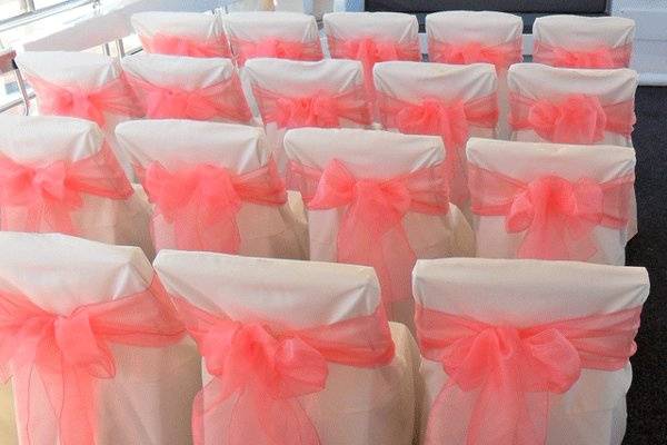 White chair covers for folding chairs with Dusty Rose Pink organza bows.