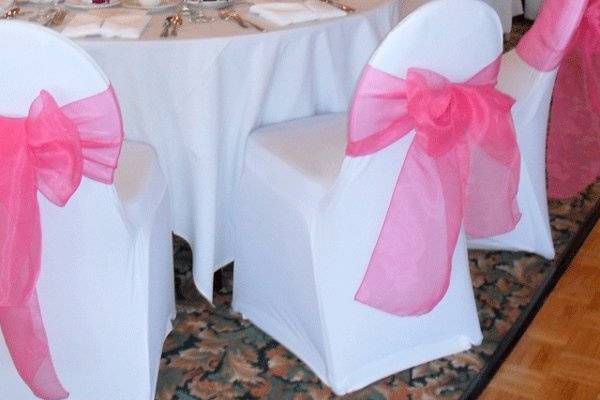 White spandex chair covers with Hot Pink organza bows.