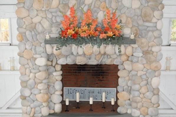 Bonnet Island wedding - sunset toned lilies, gladiolas to decorate the beautiful stone fireplace ceremony setting.