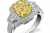 Yellow diamond engagement ring surrounded by white diamonds in 18 karat white gold.