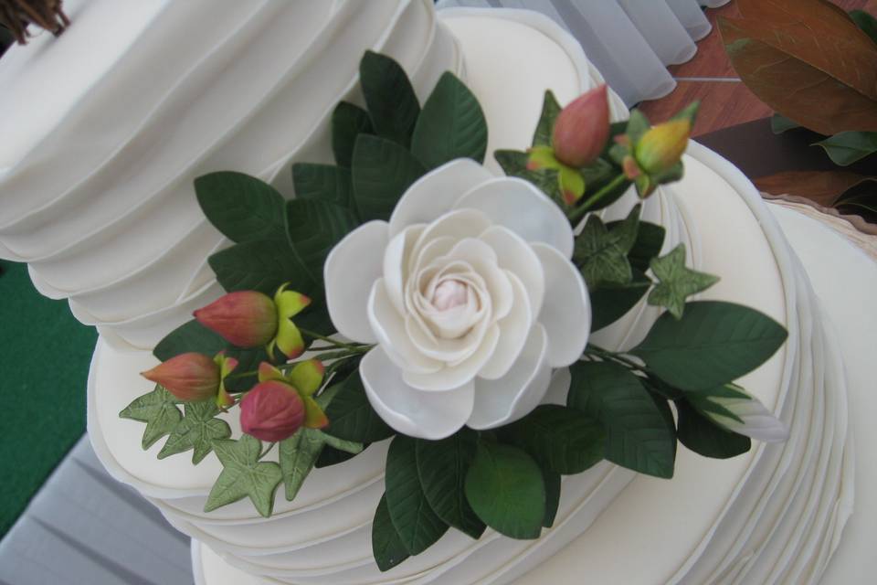 Focal point of this Glen Arbor, Michigan wedding cake is a spray of hand made sugar paste flowers including gardenia blossom, bud, and foliage, hypericum berries and ivy.