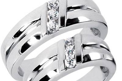 Contemporary matching his and her wedding ring crafted of 14k high polish white gold with three round cut diamonds set diagonally in each ring weighing a total of approximately 0.39 carats. Available in any size.