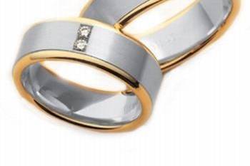 This plain and classic comfort fit his and hers wedding band feature white gold center with shiny yellow gold step edges crafted in 14k gold. Her band includes two round cut diamonds weighing approximately 0.10cts.