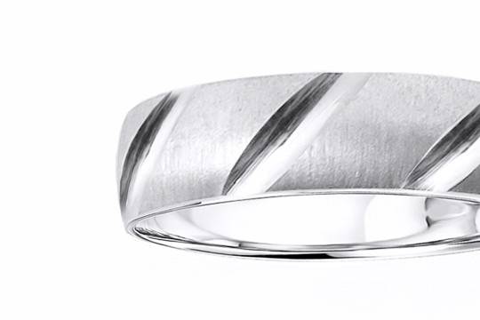 This 14k white gold wedding band with a sandstone finish has one high polish parallel cut close to one edge with an intersecting vertical cut. Smooth and silky inside for a comfort fit wear. Available in any size and width.