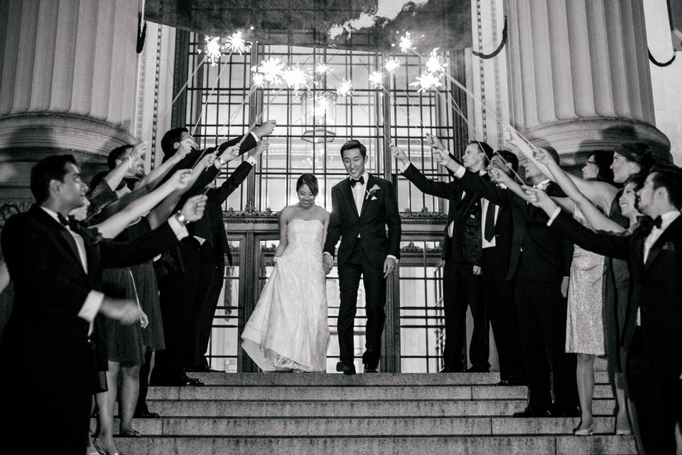 Newlywed couple and guests with sparklers