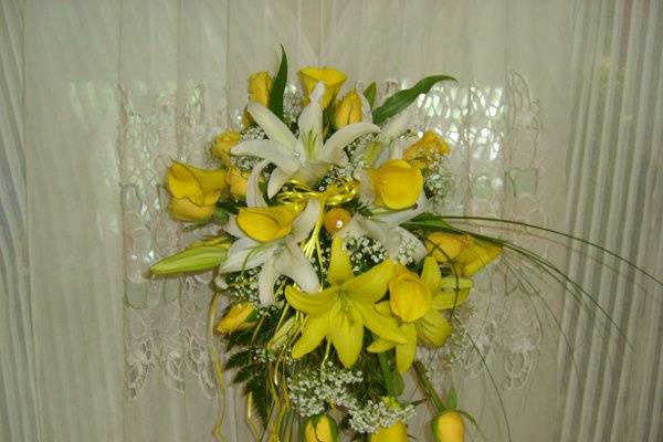 Yellow mini calla lilies, yellow roses, yellow lilies, and white lilies.