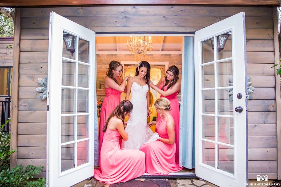 Bridesmaids helping the bride