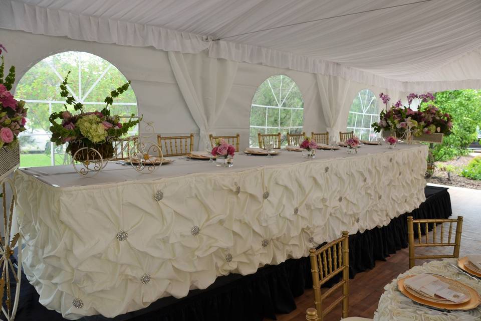 12 person head table on risers with ivory lamour satin gathered skirting with brooches