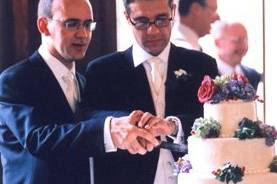 Gay couple cutting thier wedding cake.