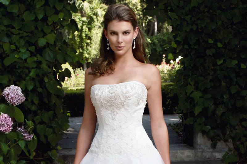 Style 2090
Glamorous trumpet shaped silhouette with flowers delicately placed throughout the skirt. This strapless gown has an asymmetric ruched dropped waist and deep “V” back neckline. Crystal buttons give the perfect amount of sparkle to this gown.