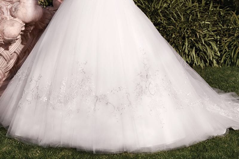 2145
Waves of raw-edged organza and tulle blend together to create flowing rosettes on this full A-line skirt. The bodice is non-beaded lace with a soft sweetheart neckline. Lace covered buttons and loops trail along the zipper. This gown features an inside hook and eye fit panel.