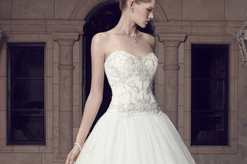 2160
Guipure Lace dropped waist bodice flows into layers of a tulle ball gown skirt. The Princess Sweetheart neckline and low “V” shaped back neckline have scalloped trim along the edges. The zipper is lined with crystal buttons