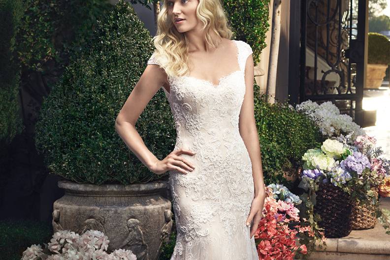 2215 <br> Fit and flare gown made of beaded lace appliqués on Chantilly Lace over Soft Tulle. Gown features a sweetheart neckline and cap sleeves. Delicate eyelash fringes goes along the entire front and back neckline. Matching fabric covered buttons with loops finish the back zipper.