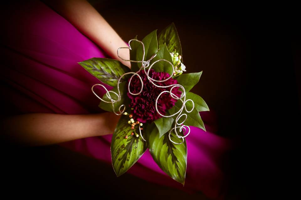 magenta carnations with decorative wire and greens