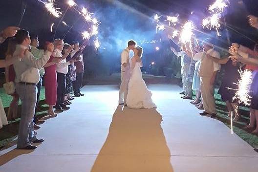 Couple embrace in front of happy loved ones