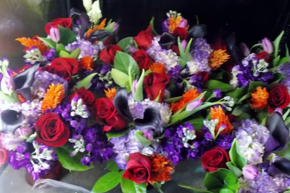 A group of bridesmaids bouquets in the cooler, the purple with a pop of red and orange makes for a stunning late summer color combination.  The girls dresses were purple but imagine those bouquets if they were have been against a red or tangerine colored dress!! Stunning!