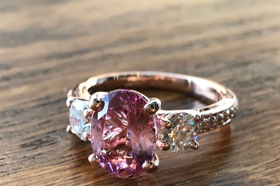 Custom Design: Three Stone Rose Gold Engagement ring with a oval Morganite center, two side diamonds, and accent diamonds on the band.