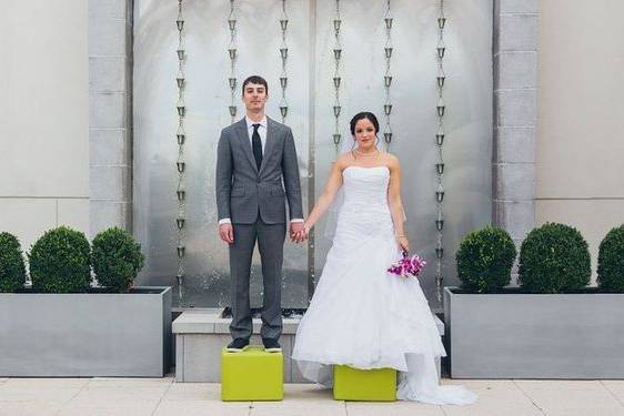 Groom and bride stepping on boxes