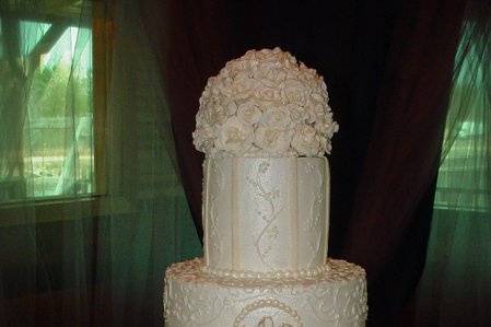 Wedding cake: Four tier buttercream with gumpaste flowers, fondant drappings and designs. Reception in Alma, Georgia