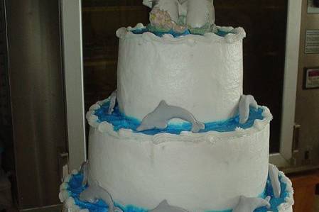 Three tier buttercream accented with fondant dolphins and seashells.