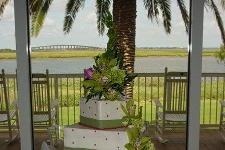 Three tier buttercream icing with fuchsia trim and dots, fondant sage green bands, accented with flowers. Reception held at Epworth By The Sea on St. Simons Island, Ga.