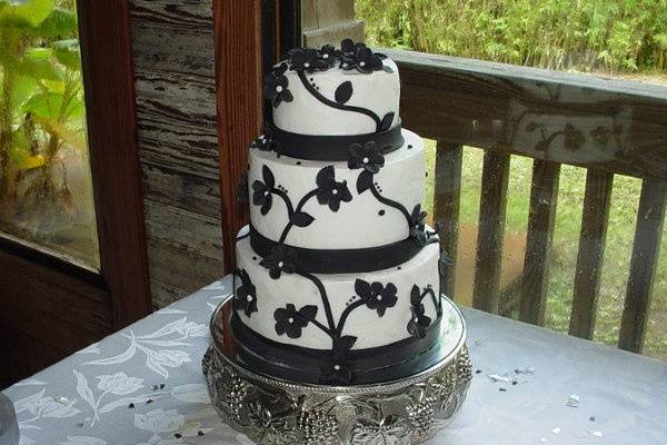 Wedding shower: Three tier buttercream with black fondant bands and flowers. Reception held at Spanky's Restaurant Mall side, Brunswick, Ga.