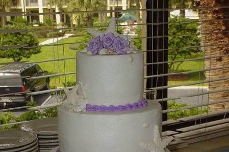 Three tier buttercream accented with fondant shells and gum paste roses. Reception held at Oceanside Inn and Suites on Jekyll Island, Ga.