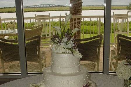 Three tier buttercream with dots, fondant bands and accented with various flowers and beads. Reception held at Epworth By The Sea, St. Simons Island, Ga.