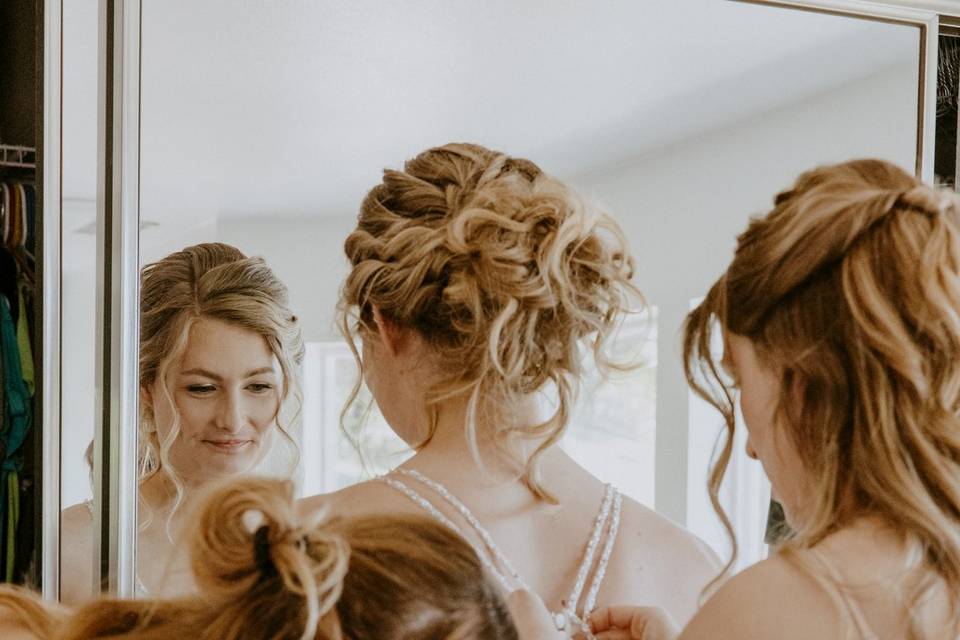 Bridesmaids helping bride