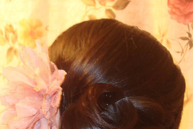 Neat wedding updo with soft pink flower