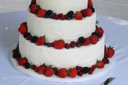 white buttercream textured for a rustic look and decorated with fresh summer berries.