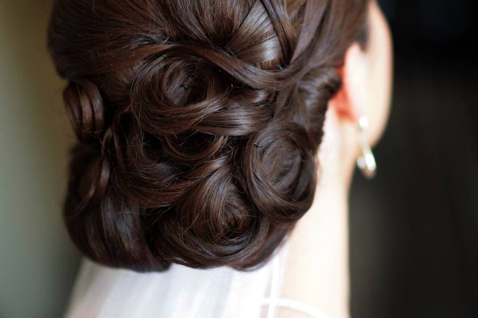 Low chignon , using her hair for placed detail to give dimension to her beautiful dark brown hair.