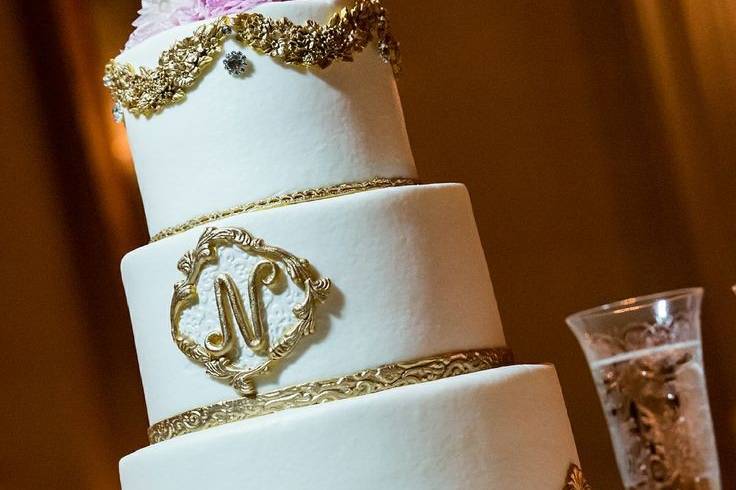 Elegant gold and white vintage cake with fresh floral.