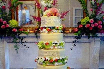 This fondant covered separated cake serves about 280 guests.  The piping matches lace on the bride's dress.  The flowers match her bouquet.