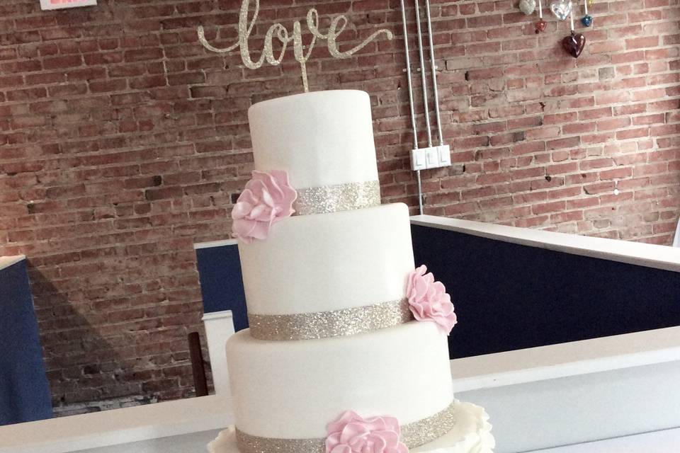 Wedding cake silver ribbon and pink flowers