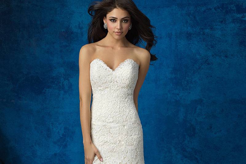 Style 9372 <br> Sprinkled with lace appliques and ending in a ruffled train, this unique ballgown features a dropped waist.