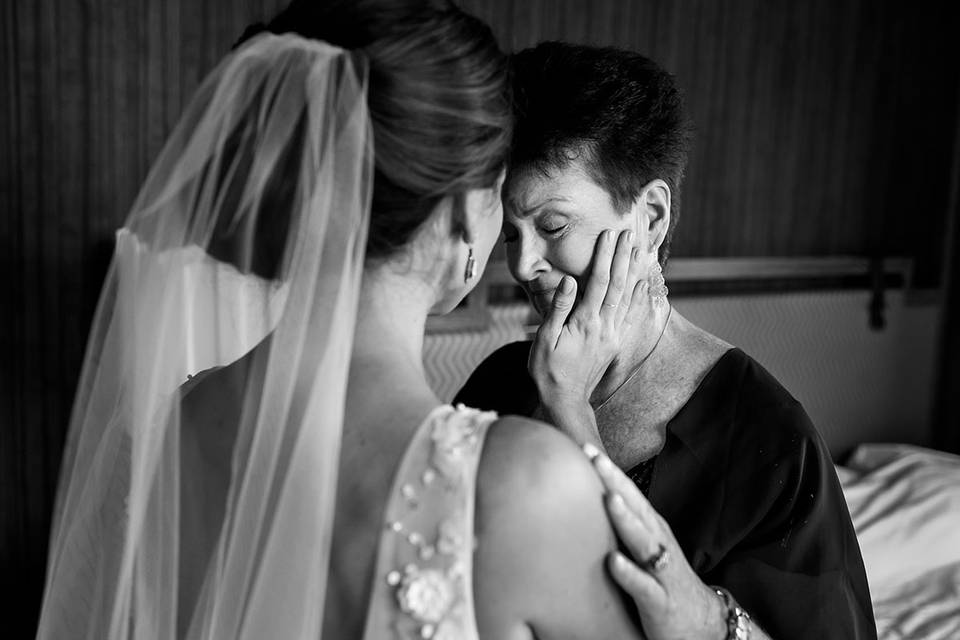 Bride comforts crying mom.