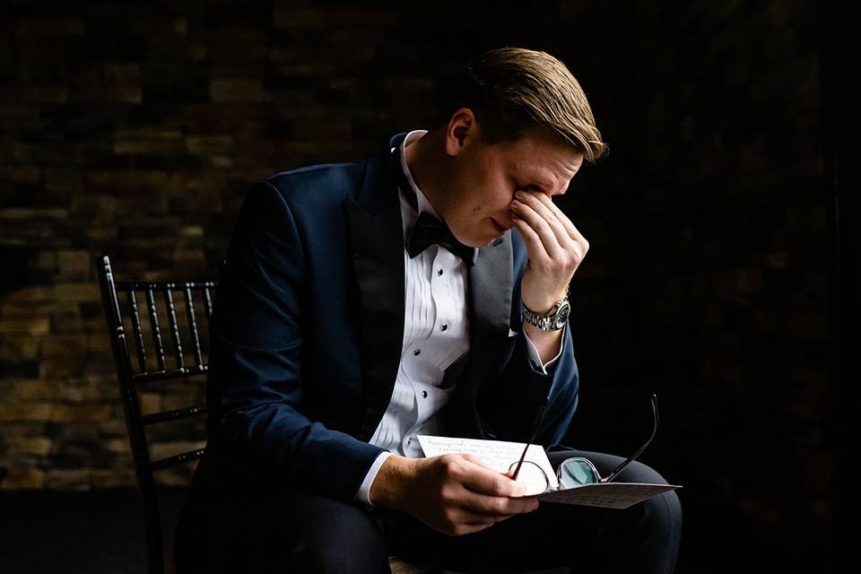 Emotional groom reading card.